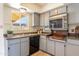 Galley kitchen features tiled floors, grey cabinetry, and window at 8355 E Thomas Rd, Scottsdale, AZ 85251