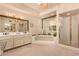 Bright bathroom featuring dual sinks, a soaking tub, large mirrors and a glass shower at 9090 N 86Th Pl, Scottsdale, AZ 85258