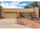 Home's inviting exterior features a gated front patio, mature landscaping, and a two-car garage at 9090 N 86Th Pl, Scottsdale, AZ 85258