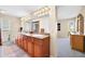 Bathroom with double sinks, granite counters, wood cabinetry, and a walk-in shower at 9309 W Briarwood Cir, Sun City, AZ 85351