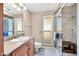 Bright bathroom with a granite countertop vanity and a glass enclosed shower with a built-in bench at 9309 W Briarwood Cir, Sun City, AZ 85351