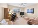 A well lit bedroom featuring a desk, chairs, and a television, creating a comfortable and functional space at 9309 W Briarwood Cir, Sun City, AZ 85351