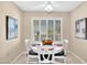 A cozy breakfast nook features a white table, chairs, shuttered windows, and artwork at 9309 W Briarwood Cir, Sun City, AZ 85351