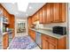 A well-lit kitchen featuring wooden cabinets, stainless steel appliances, and a view into the dining room at 9309 W Briarwood Cir, Sun City, AZ 85351