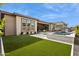 Expansive backyard featuring a pool, outdoor kitchen, covered patio, and lush green lawn at 9370 E Wethersfield Rd, Scottsdale, AZ 85260