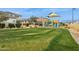 Community park featuring a colorful playground on a grassy lawn, surrounded by homes and landscaping at 9370 E Wethersfield Rd, Scottsdale, AZ 85260