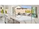 Close-up of kitchen island with a white countertop, stainless steel sink, and view of backyard with pool at 9370 E Wethersfield Rd, Scottsdale, AZ 85260