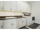 Bright laundry room with a sink, counter space, ample cabinets, and modern washer and dryer units at 9370 E Wethersfield Rd, Scottsdale, AZ 85260