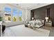 Stunning main bedroom with a dark accent wall, stylish seating, and bright natural light from large windows at 9370 E Wethersfield Rd, Scottsdale, AZ 85260