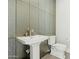 Elegant powder room with textured wall and modern pedestal sink at 9370 E Wethersfield Rd, Scottsdale, AZ 85260