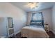 Bright bedroom with dark wood floors, a ceiling fan, and a large window with blue patterned curtains at 99 W Circle Dr, Florence, AZ 85132