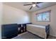 Simple bedroom with a single bed, dresser, and view from the large window at 99 W Circle Dr, Florence, AZ 85132