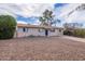 Charming single-story home with a gravel front yard and blue front door at 99 W Circle Dr, Florence, AZ 85132