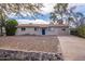 Charming single-story home showcasing a low-maintenance rock yard and inviting blue front door at 99 W Circle Dr, Florence, AZ 85132