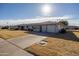 Quaint single-story home with neat desert landscaping, a two-car garage, and an American flag at 10019 W Shasta Dr, Sun City, AZ 85351