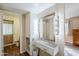 Bathroom vanity with Hollywood mirror and sink, with cabinets and a view into the water closet at 10407 W Mission Ln, Sun City, AZ 85351