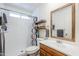 Bathroom featuring a shower, wood-look mirror, and storage shelves at 10407 W Mission Ln, Sun City, AZ 85351