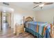 Bedroom with wood floors, ceiling fan, a large bed with a colorful blanket and hall access at 10407 W Mission Ln, Sun City, AZ 85351