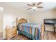 Bedroom with wood floors, ceiling fan, a large bed with a colorful blanket and wood furniture at 10407 W Mission Ln, Sun City, AZ 85351