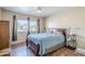 Bedroom featuring wood-look floors, a ceiling fan, and a large window with views at 10407 W Mission Ln, Sun City, AZ 85351