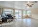 Bright bonus room with tile floors, large windows, sliding glass doors, and a ceiling fan at 10407 W Mission Ln, Sun City, AZ 85351