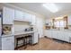 Bright kitchen featuring white cabinetry, a breakfast bar with seating, and wood-look flooring at 10407 W Mission Ln, Sun City, AZ 85351