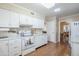 Bright kitchen featuring white cabinetry, granite countertops, and wood-look flooring at 10407 W Mission Ln, Sun City, AZ 85351