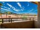 Balcony view of the neighborhood's red tile roofs, palm trees, and distant mountains under a bright, cloudy sky at 10410 N Cave Creek Rd # 2007, Phoenix, AZ 85020