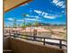 Balcony view of the neighborhood's red tile roofs, palm trees, and distant mountains under a bright, cloudy sky at 10410 N Cave Creek Rd # 2007, Phoenix, AZ 85020