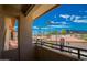 View from the balcony of palm trees and buildings with red tile roofs under a partly cloudy, bright blue sky at 10410 N Cave Creek Rd # 2007, Phoenix, AZ 85020