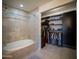 Well-lit bathroom with bathtub adjacent to a closet featuring lots of storage space at 10410 N Cave Creek Rd # 2007, Phoenix, AZ 85020