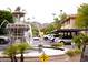 Outdoor shot of a fountain with lush green plants, a parking area, and distant mountains in the background at 10410 N Cave Creek Rd # 2007, Phoenix, AZ 85020