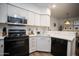 Well-lit kitchen with white cabinets, black appliances, and stylish backsplash, offering both functionality and charm at 10410 N Cave Creek Rd # 2007, Phoenix, AZ 85020