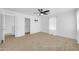 Bright, carpeted bedroom features a ceiling fan, window, closet and ensuite bathroom at 110 N 66Th Ave, Phoenix, AZ 85043