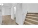 Hallway with stairway, herringbone floors, and a glimpse of the downstairs bathroom at 110 N 66Th Ave, Phoenix, AZ 85043