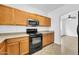 Kitchen with wooden cabinets, black appliances, and granite countertops at 110 N 66Th Ave, Phoenix, AZ 85043