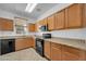 Well-lit kitchen with wooden cabinetry, granite countertops, and a complete set of appliances at 110 N 66Th Ave, Phoenix, AZ 85043