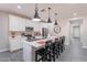 Modern kitchen with stainless steel appliances, a spacious island with bar stool seating, and gray wood flooring at 1236 E Silver Reef Dr, Casa Grande, AZ 85122