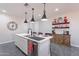 Bright kitchen with stainless steel appliances, kitchen island, and modern pendant lighting at 1236 E Silver Reef Dr, Casa Grande, AZ 85122