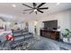 Open-concept living room features gray leather couch and view of the kitchen and a flat screen television at 1236 E Silver Reef Dr, Casa Grande, AZ 85122