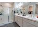 This well-lit bathroom includes double sinks with modern faucets, a glass shower, and gray tile floors at 1236 E Silver Reef Dr, Casa Grande, AZ 85122