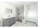 Bathroom featuring modern vanity, frameless mirror, walk-in shower, and marble-look tile at 12408 N Cherry Hills W Dr, Sun City, AZ 85351