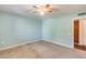 A carpeted bedroom with a ceiling fan and a view into an adjacent closet space at 12515 W Prospect Dr, Sun City West, AZ 85375