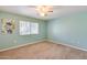 Bright bedroom features a ceiling fan, neutral carpet and a window for ample natural light at 12515 W Prospect Dr, Sun City West, AZ 85375