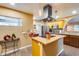 Bright kitchen features a center island with a stainless steel range hood and butcher block countertop at 12515 W Prospect Dr, Sun City West, AZ 85375