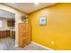 Bright kitchen eat-in area featuring wood-look vinyl plank flooring, custom cabinets, and yellow accent wall at 12515 W Prospect Dr, Sun City West, AZ 85375