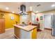 Open kitchen featuring a center island, butcher block countertop, and stainless steel range hood at 12515 W Prospect Dr, Sun City West, AZ 85375