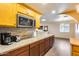 Kitchen featuring granite countertops, custom cabinets, stainless steel microwave, and wood-look vinyl plank flooring at 12515 W Prospect Dr, Sun City West, AZ 85375