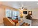 Inviting living room featuring a leather sofa, ceiling fan, and access to the patio through shuttered doors at 12515 W Prospect Dr, Sun City West, AZ 85375