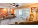 Comfortable living room featuring a leather sofa, ceiling fan, and shuttered doors leading to the outdoor space at 12515 W Prospect Dr, Sun City West, AZ 85375